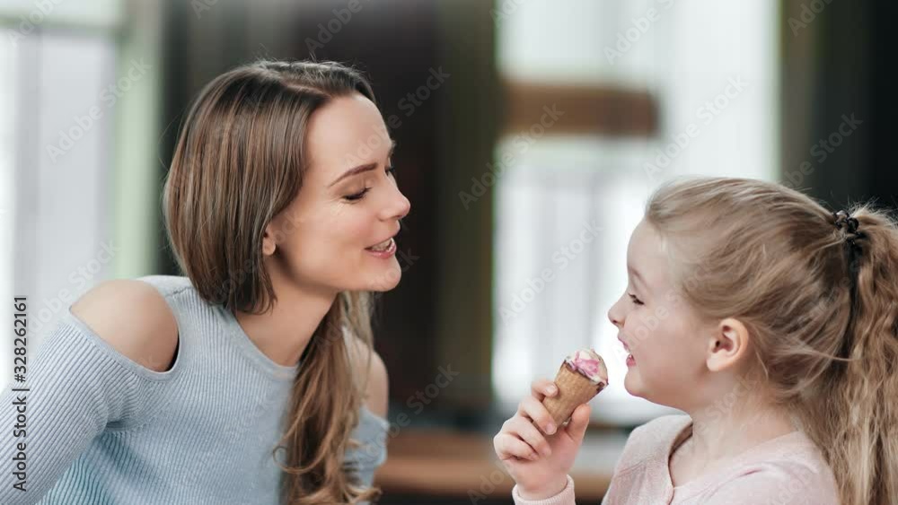 Laughing young woman playing with daughter during eating ice cream. Close up shot on 4k RED camera