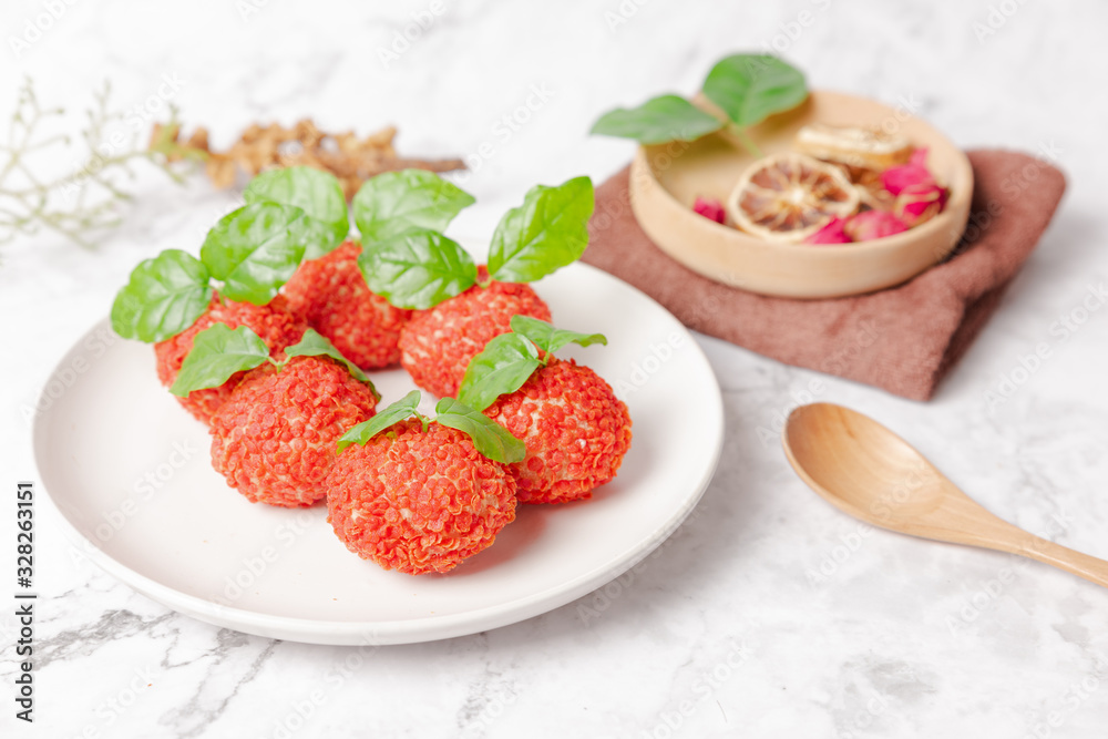 Red dessert like litchi on a white plate Red dessert like litchi on a white plate