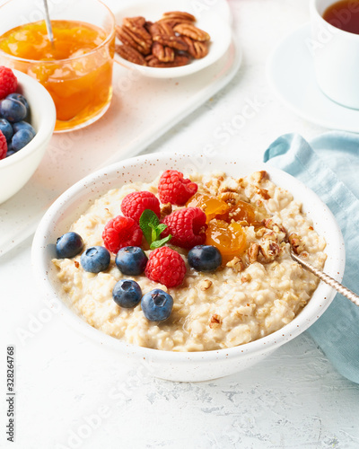 Oatmeal porridge with blueberry, raspberries, side view, close up, vertical, breakfast with berries