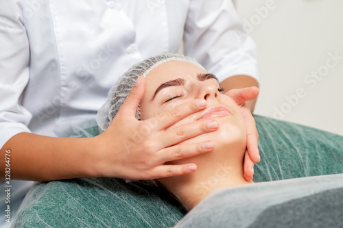 Face massage of woman.