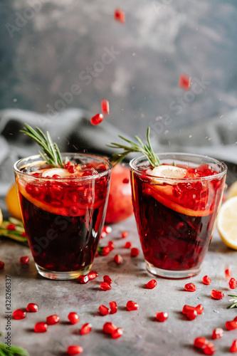 Pomegranate drink in a glass with lemon and rosemary