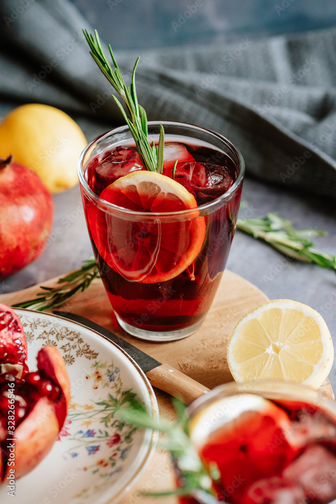 Pomegranate drink in a glass with lemon and rosemary Pomegranate drink in a glass with lemon and rosemary