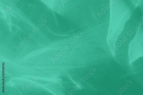 Trendy mint colored abstract background with light and shadows caustic effect. Light passes through a glass. 2020 color trend
