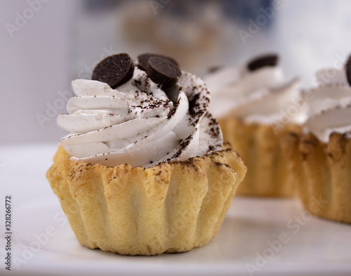 Cake baskets with white cream of shortbread with a sprinkle of cocoa. Close up