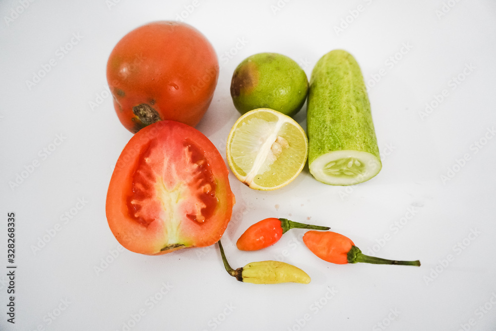photo of tomato, lemon, cucumber, chili with white background