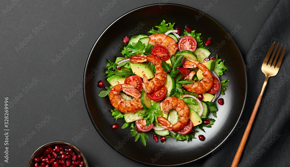 Shrimps salad, avocado, lettuce, cherry tomatoes. Home made vegetarian shrimp salad. Seafood concept. Tasty veg mixed leaves, grilled prawn shrimps in plate on black background. Shrimps salad, avocado, lettuce, cherry tomatoes. Home made vegetarian shrimp salad. Seafood concept. Tasty veg mixed leaves, grilled prawn shrimps in plate on black background.