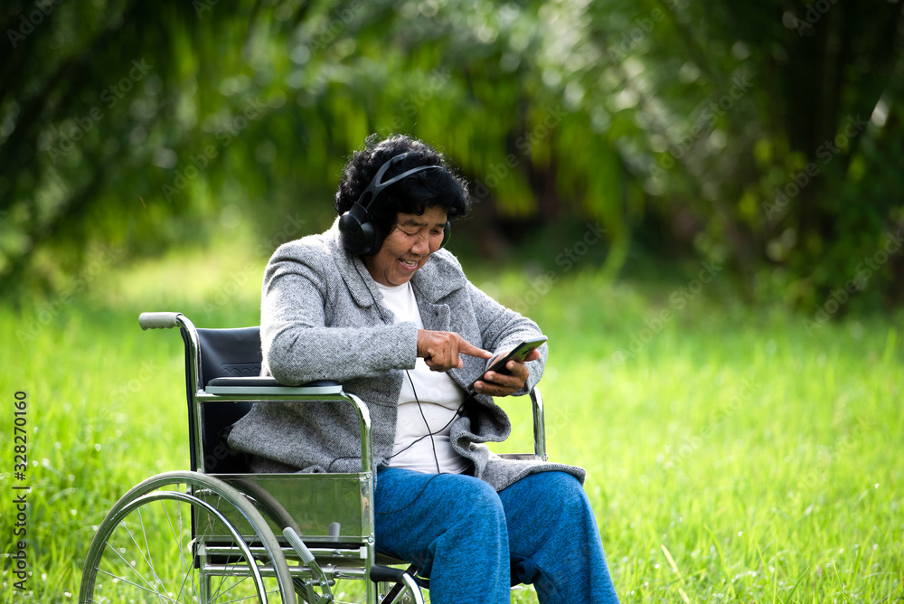 Fototapeta premium Senior women are sick with headphones and tablets on the lawn or in the hospital.
