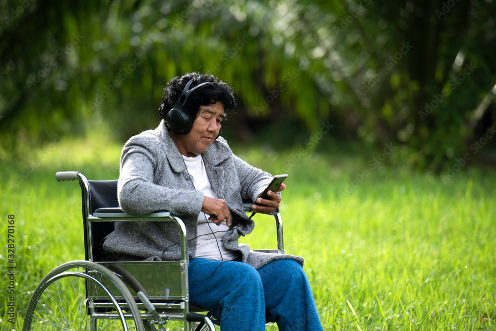 Fototapeta premium Senior women are sick with headphones and tablets on the lawn or in the hospital.