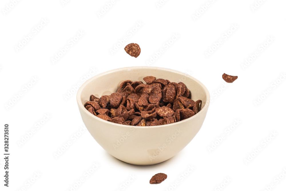 Chocolate corn flakes falling to the white bowl isolated on white. Motion. Chocolate corn flakes falling to the white bowl isolated on white. Motion.