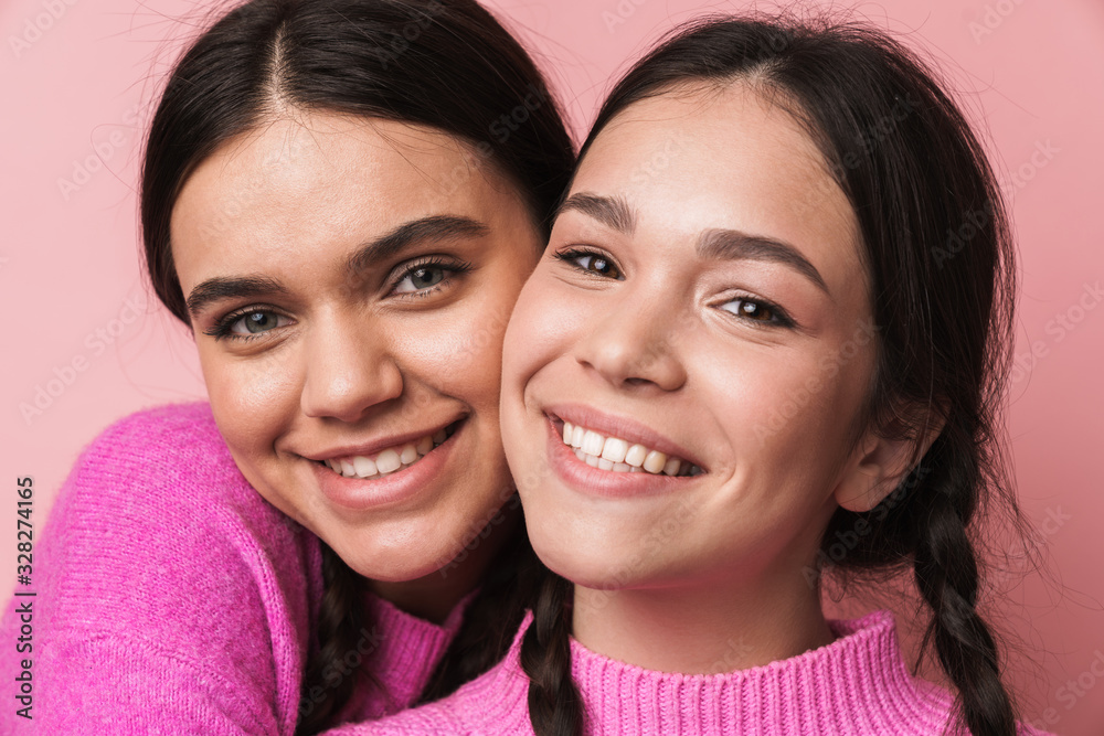 Two cheerful cute teenage girls having fun isolated Two cheerful cute teenage girls having fun isolated