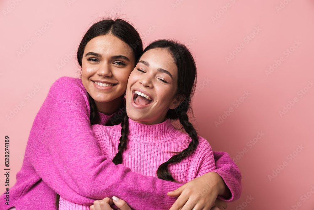 Two cheerful cute teenage girls having fun isolated Two cheerful cute teenage girls having fun isolated