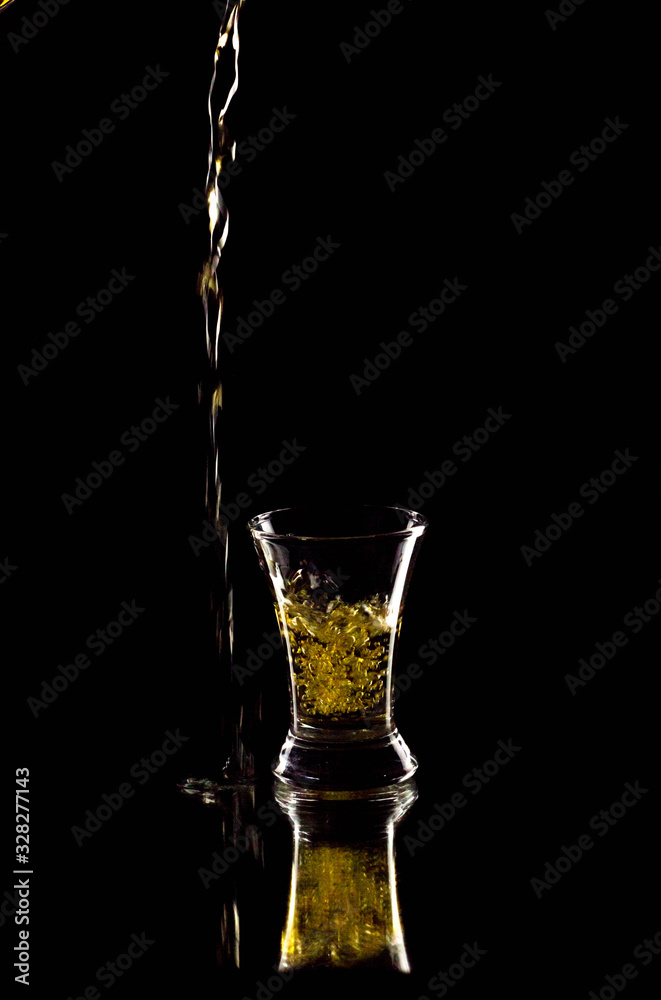 Silhouette of a glass on a black background, a red drink is poured on top Silhouette of a glass on a black background, a red drink is poured on top