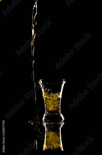 Silhouette of a glass on a black background, a red drink is poured on top