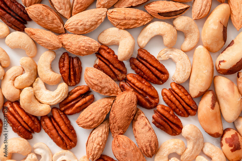 Pattern of assorted nuts pecans, macadamis, brazil nut, cashews, almonds on a gray background. Top view, flat lay