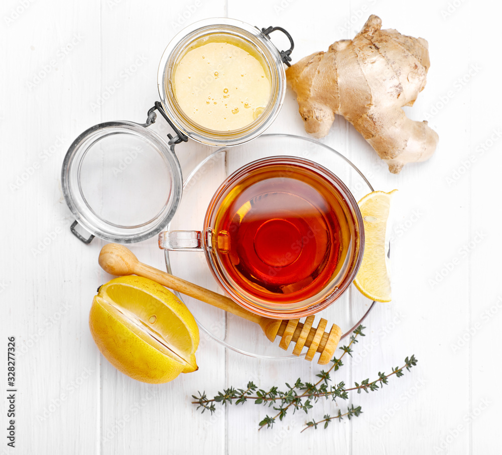 Ginger tea with lemon honey and thyme at white wooden board in rustic style. Top view. Ginger tea with lemon honey and thyme at white wooden board in rustic style. Top view.
