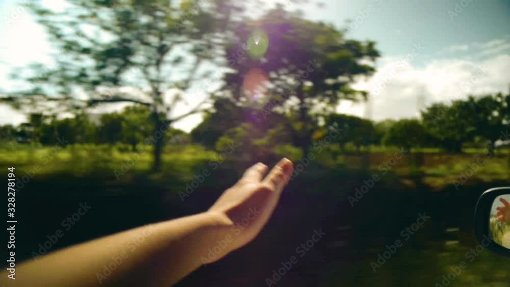 Point of view shot of a woman's hand in the breeze during a sunny road trip. POV, personal perspective. Point of view shot of a woman's hand in the breeze during a sunny road trip. POV, personal perspective.