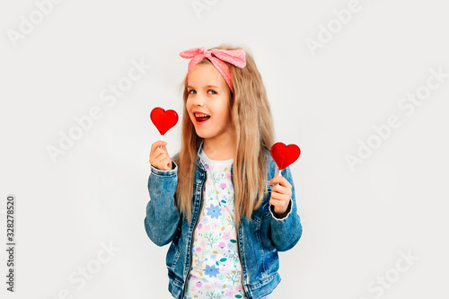 Portrait of a beautiful stylish fashionable girl in glasses, with a heart-shaped lollipop, on a white background, free time summer vacation #328278520