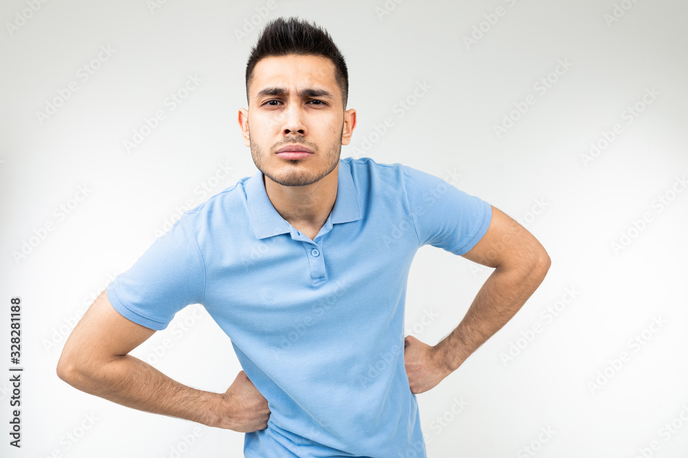 Caucasian handsome guy in a blue T-shirt stood in a pose and is not inferior on a white studio background Caucasian handsome guy in a blue T-shirt stood in a pose and is not inferior on a white studio background
