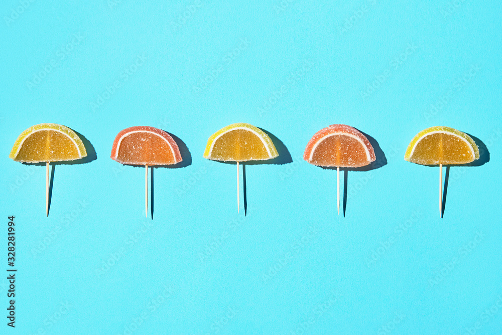 Obraz premium yellow and orange marmalade slices on aqua background. copy space. top view. flat lay.