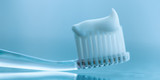 Transparent plastic toothbrush with white toothpaste. Macro image.