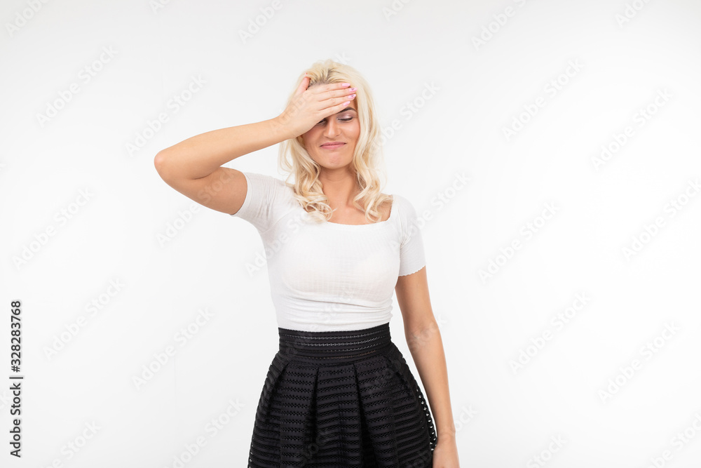 Fototapeta premium girl shows a headache while holding a hand near the forehead on a white background