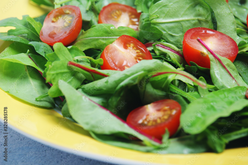 A plate with green salad and cherry tomatoes A plate with green salad and cherry tomatoes