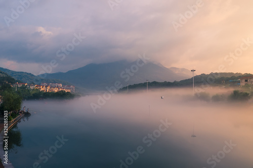 In the early morning of the city, the sky is full of rosy clouds, and the advection fog flows around the river, hazy and beautiful
