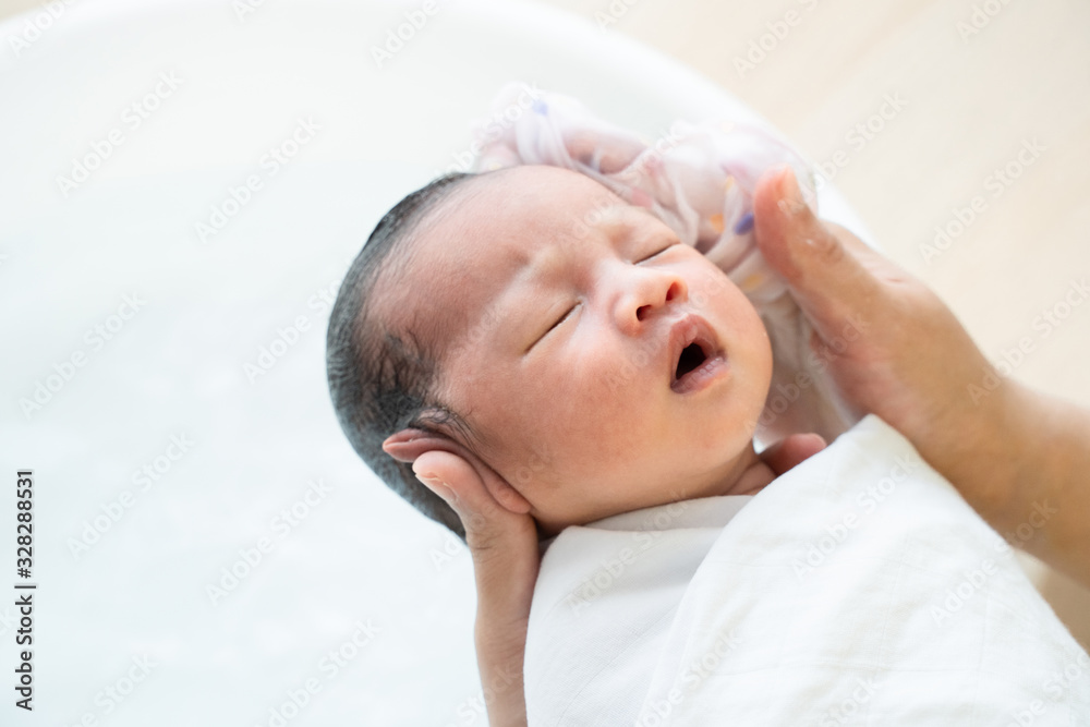 Mother is washing baby hair. Mom cleaning her baby hair. Mother is washing baby hair. Mom cleaning her baby hair.