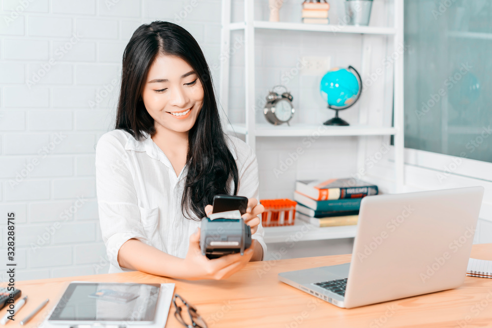 Asian girl holds QR Code on smartphone over credit card machine in supermarket shopping mall counter service for smart life security, internet of things,smart pay online for business service concept