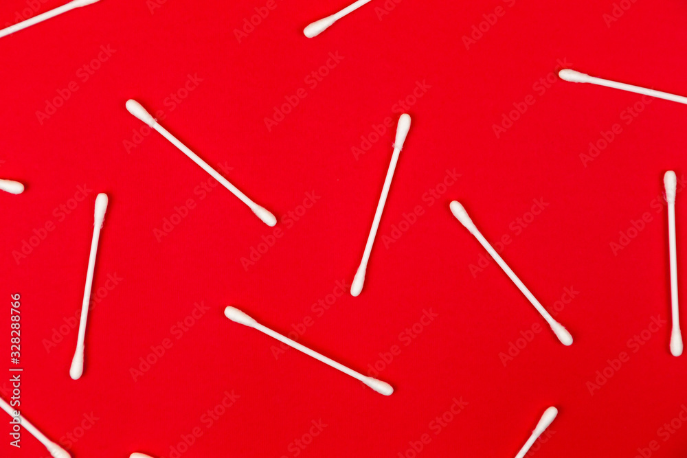 Flat lay composition with cotton swabs on red background. Top view ear sticks Flat lay composition with cotton swabs on red background. Top view ear sticks