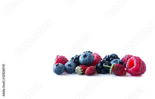 Berries isolated on white background. Ripe blueberries, blackberries, raspberries and wild strawberries. Background of mix berries with copy space for text. Mix berries on white background.