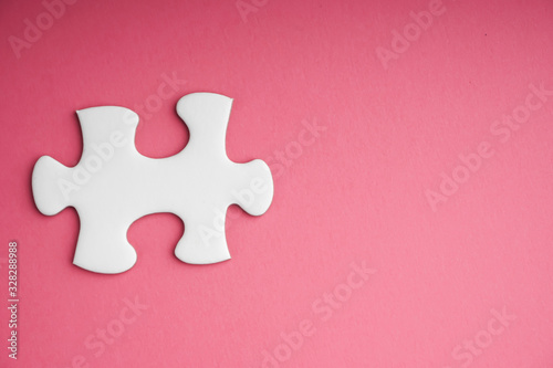 White jigsaw puzzle pieces on pink background. Copy space