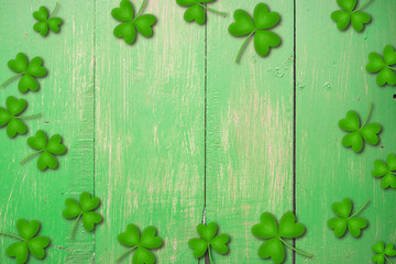 Shamrocks on green wooden table a symbol og St. Patricks Day. Bbanner with corner border of shamrocks.Textured pattern.