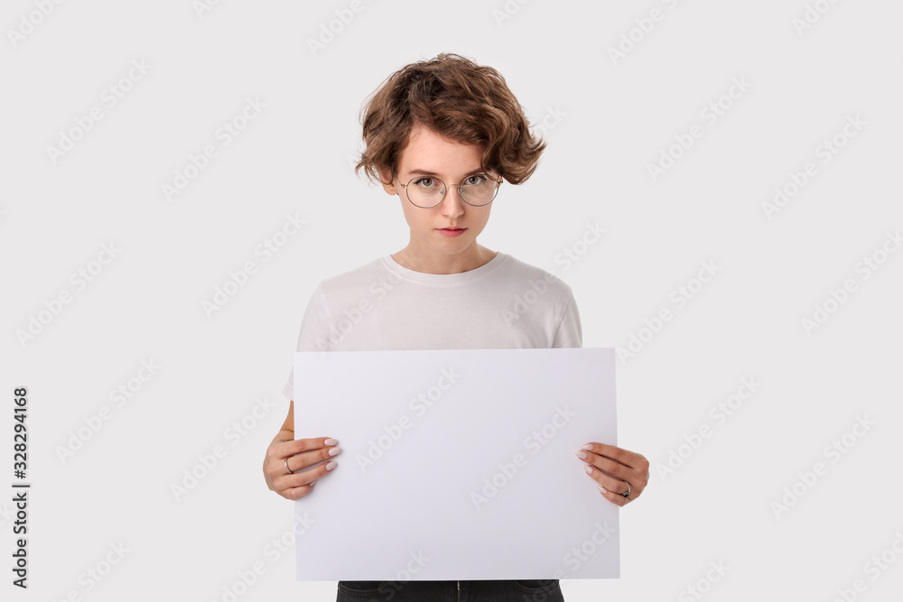 Pretty young woman with eyeglass holding empty blank paper board with copy space for text. Pretty young woman with eyeglass holding empty blank paper board with copy space for text.