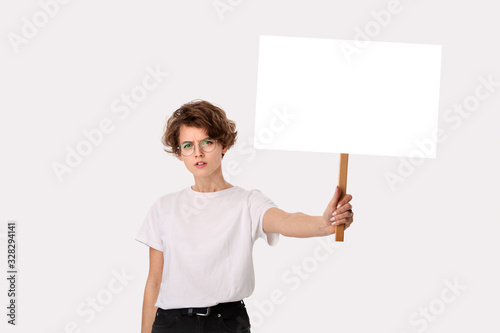 Concerned female protester holding empty signboard with copy space. photo