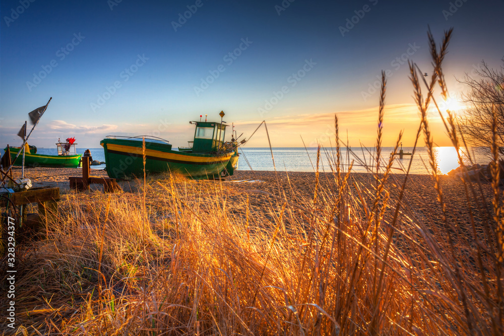 Fototapeta premium Fishing boats on the Baltic Sea beach at sunrise in Gdynia Orlowo, Poland