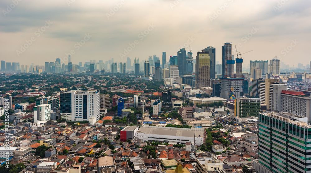 Obraz premium Jakarta, Indonesia - 19th Feb 2019: Aerial or bird eye view of Jakarta Central Business District (Sudirman and Kuningan). Rich and poor inequality. Taken at a cloudy afternoon.