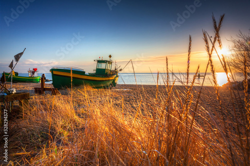 Fototapeta Naklejka Na Ścianę i Meble -  Fishing boats on the Baltic Sea beach at sunrise in Gdynia Orlowo, Poland
