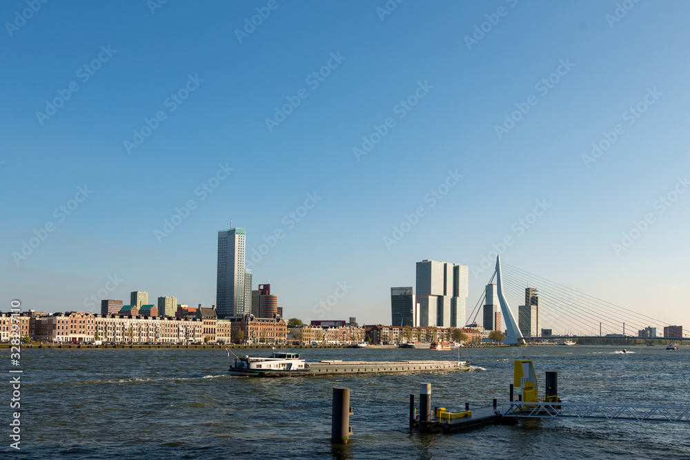 Skyline of Rotterdam over the Maas river with a boat in the Netherlands