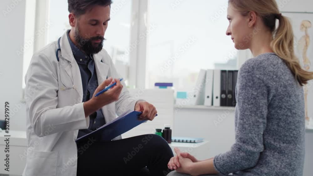 Handheld view of woman speaks to doctor about her ailment. Shot with RED helium camera in 8K Handheld view of woman speaks to doctor about her ailment. Shot with RED helium camera in 8K