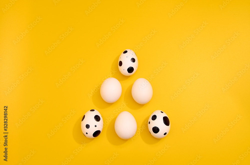 Obraz premium Many White eggs with green myrtle leaves pattern on yellow color background. Spring and Easter holiday concept with copy space.