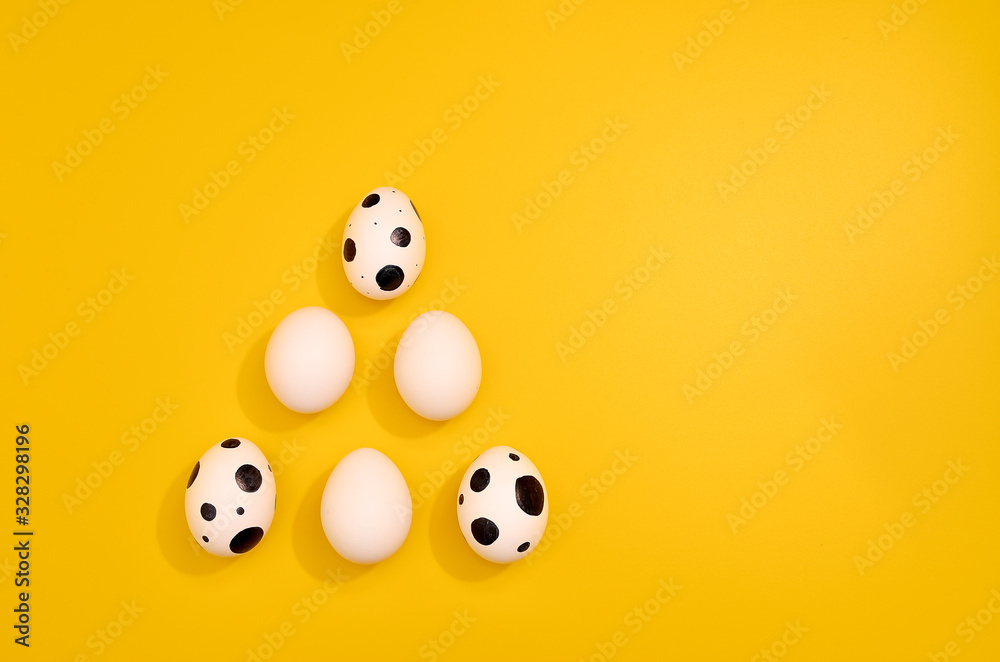 Naklejka premium Many White eggs with green myrtle leaves pattern on yellow color background. Spring and Easter holiday concept with copy space.