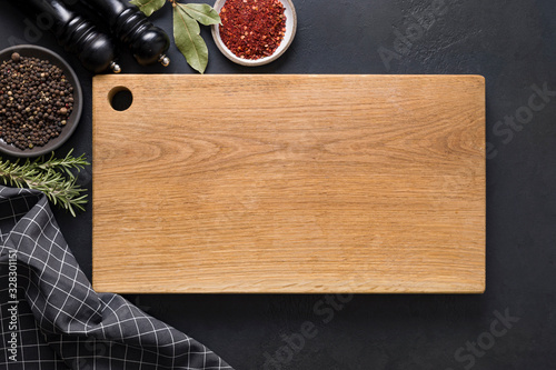Bild auf Leinwand Kitchen cutting wooden board with spices and ingredients for cooking on black