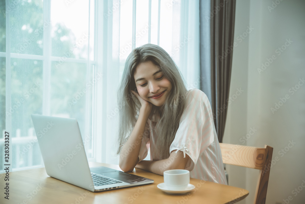 Lazy bored asian woman using laptop in the morning. Lazy bored asian woman using laptop in the morning.