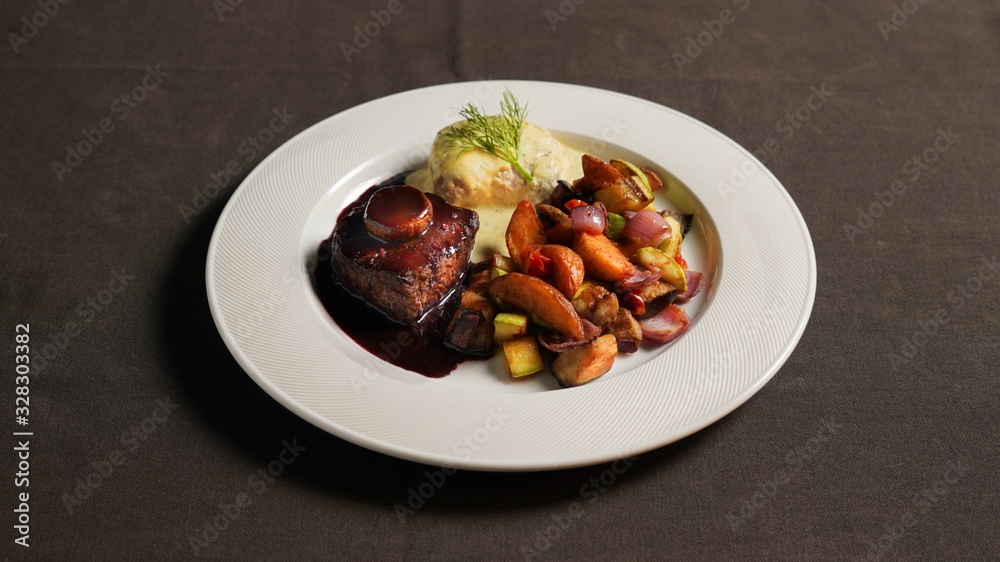 Beef steak with soy sauce, baked potatoes and vegetables. Beef steak with soy sauce, baked potatoes and vegetables.