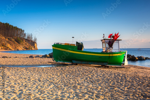 Fototapeta Naklejka Na Ścianę i Meble -  Fishing boats on the Baltic Sea beach at sunrise in Gdynia Orlowo, Poland