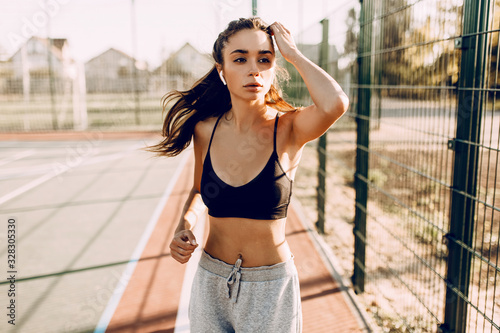Image of a young strong fitness woman outdoors  on a morning jog