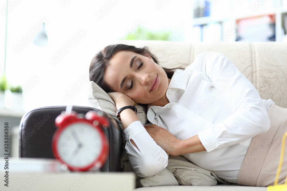 Girl sleeps after work couch, table an alarm clock. To carry out quick shopping only in relevant stores. Girl sleeps in clothes on couch in office without waiting for an audience with boss Girl sleeps after work couch, table an alarm clock. To carry out quick shopping only in relevant stores. Girl sleeps in clothes on couch in office without waiting for an audience with boss