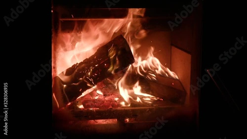 A roaring fire in a wood burning stove. Wooden logs blazing away inside a modern wood burner. This is a UK Defra approved stove for burning wood in a smoke controlled area. photo