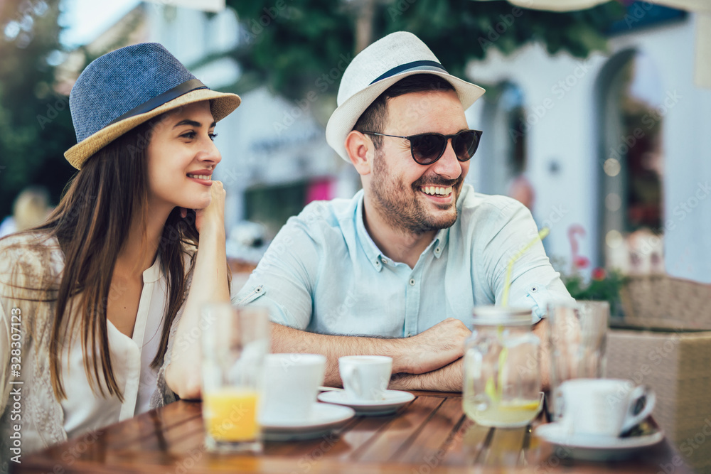 Beautiful loving couple sitting in a cafe enjoying in coffee and conversatio Beautiful loving couple sitting in a cafe enjoying in coffee and conversatio